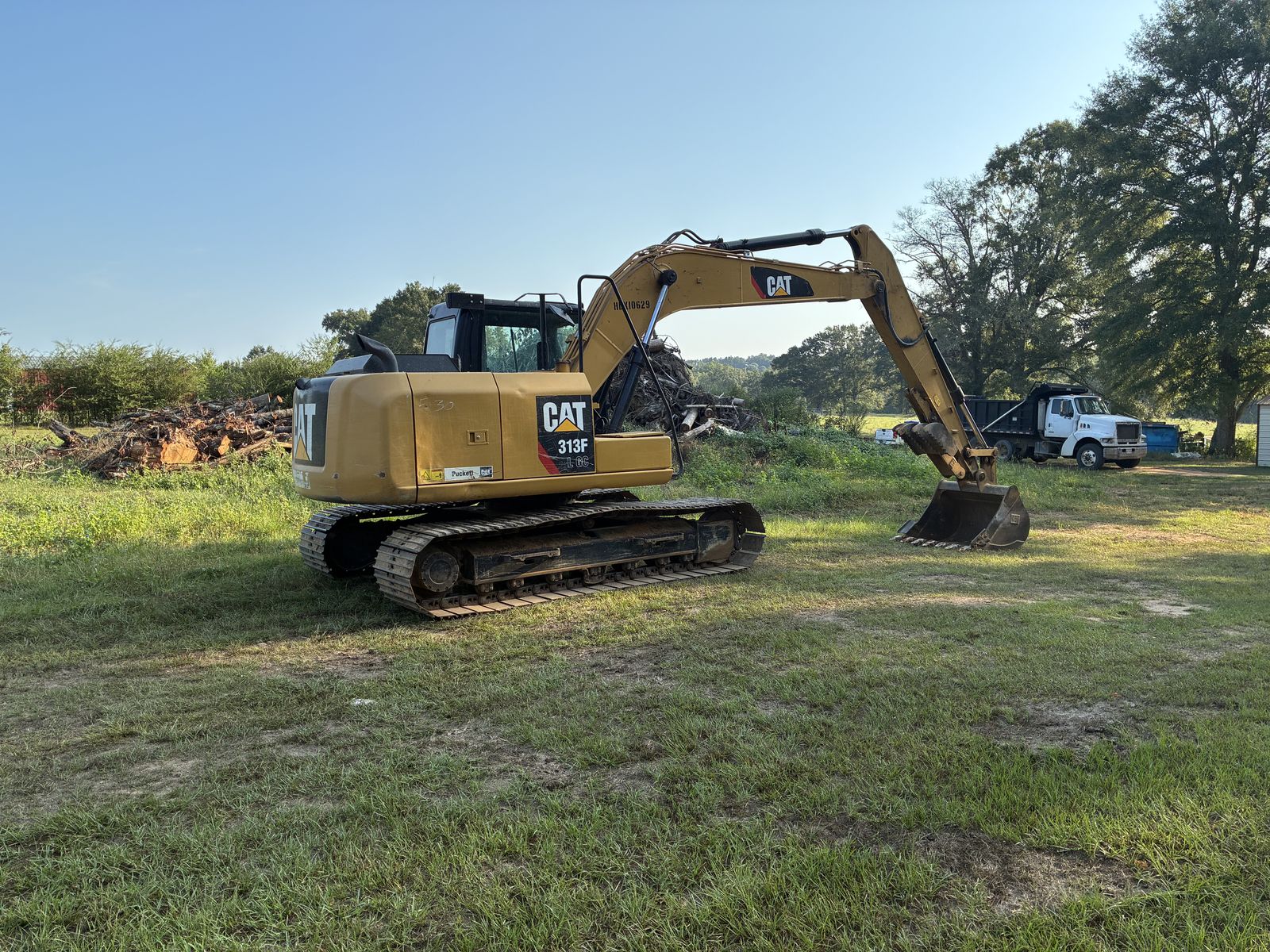 Cat 313F L GC excavator working near a cleared brush pile