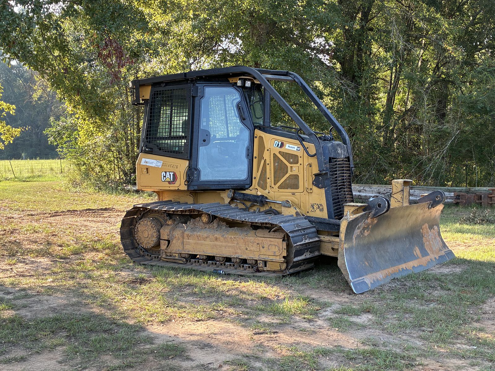 Cat D1 dozer parked in a shaded clearing