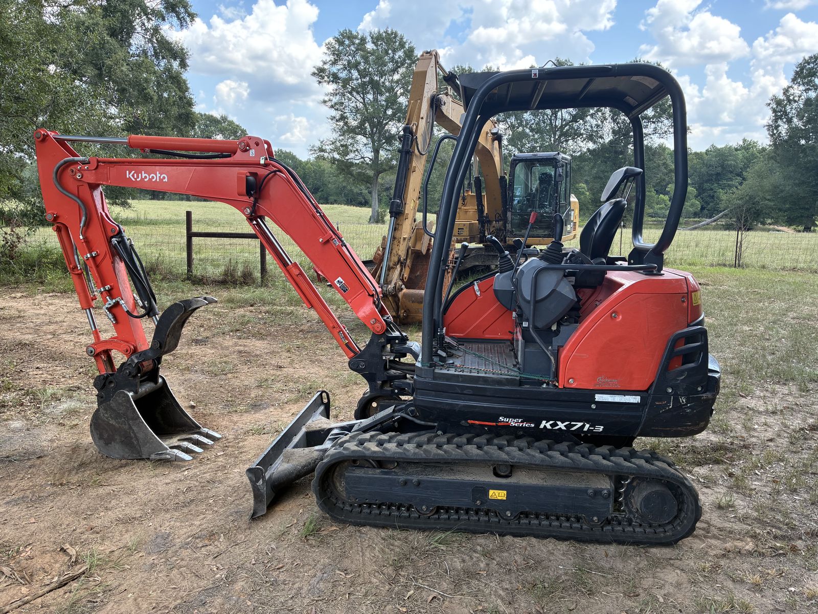 Kubota KX71-3 mini excavator with canopy in an open field